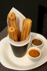 Churros con chocolate served in a restaurant.