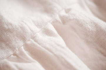 White linen textile dress closeup. Selective focus.