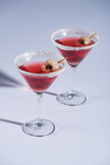 red Halloween cocktails with decoration in glasses on white surface