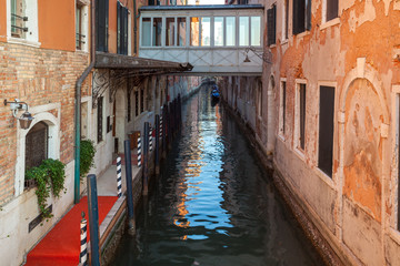 Fototapeta na wymiar Boats on narrow canal between colorful historic houses in Venice.