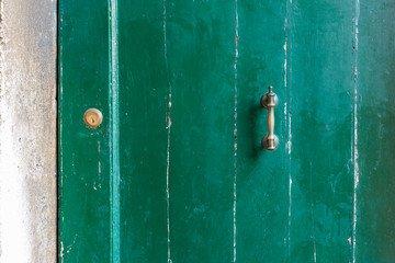 Old locked door with peeling green paint.