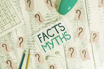 Writing note showing Facts Myths. Business concept for work based on imagination rather than on real life difference Writing tools and scribbled paper on top of the wooden table