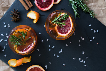Negroni cocktail on black background served with a slice of orange and rosemary. Old cocktail classics. Italian aperitivo. Flatlay