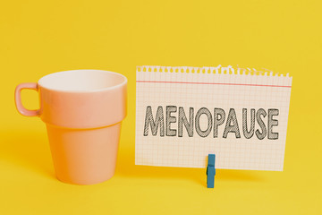 Writing note showing Menopause. Business concept for Period of peranalysisent cessation or end of menstruation cycle Cup empty paper blue clothespin rectangle shaped reminder yellow office