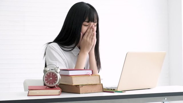 Happy asian teenage checking results of final exam with laptop computer