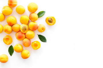Fruit background with apricots and leaves on white background top view space for text
