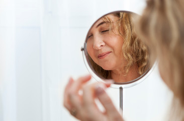 beautiful adult woman in the morning at the mirror.