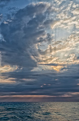 Fototapeta na wymiar Sunset, cloudy sky and sea