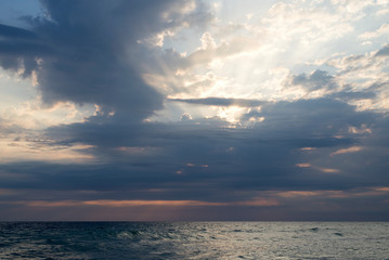 Naklejka na ściany i meble Sunset, cloudy sky and sea