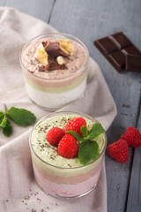 Chia seed pudding with three flavors, cocoa, matcha and strawberry with yoghurt, chocolate and mint leaves. Vertical orientation