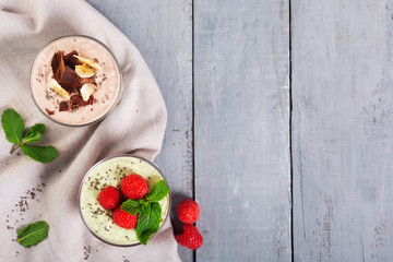 Chia seed pudding with three flavors, cocoa, matcha and strawberry with yoghurt, chocolate and mint leaves. Top view with copy space