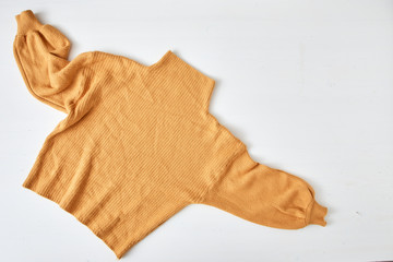 knitted yellow sweater on white table