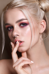 Young blonde beautiful girl with the colorfull make-up, bunches hairstyle, red and lilac smoky eyes - obrazy, fototapety, plakaty