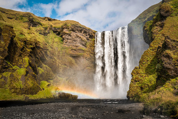 Beautiful waterfall and a rainbow next to it. Skogafoss, Iceland.