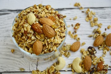 Fototapeta premium granola in a glass jar on a white wooden background with place for text