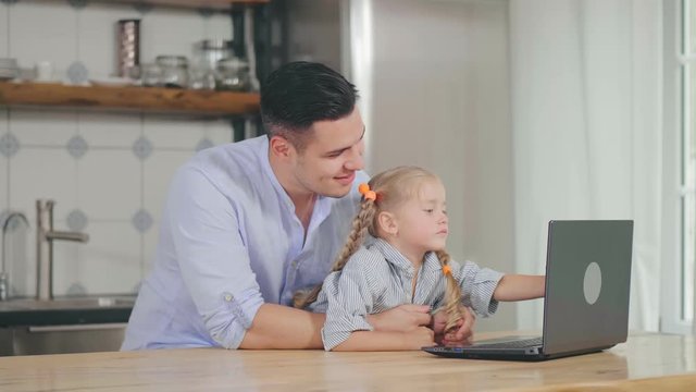 Dad spending free time with daughter using laptop