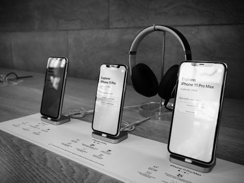 Paris, France - Sep 20, 2019: The new iPhone 11, 11 Pro and Pro Max range displayed in Apple Store next to Beats by Dr Dre Headphones black and white image