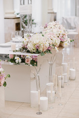 The groom and bride 's beautiful wedding table is decorated with flowers and lots of different candles.
