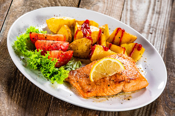 Fried salmon with baked potatoes and vegetables