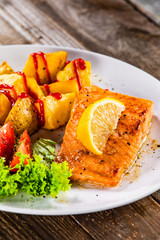 Fried salmon with baked potatoes and vegetables