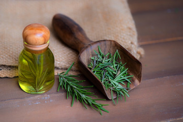 Natural rosemary essential oil on wood background