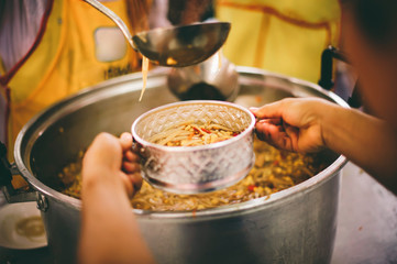 Homeless people receive delicious charity food from volunteers: concept of helping by donating food