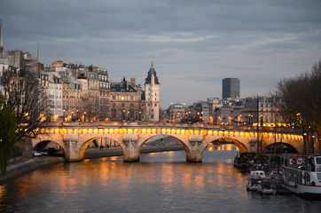 El Pont Neuf de noche con reflejo en el río Sena.