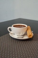 Churros con chocolate served in a restaurant.