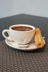 Churros con chocolate served in a restaurant.