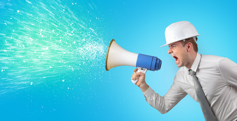 Fototapeta premium Young architect constructor yelling with megaphone and sparkling sounds