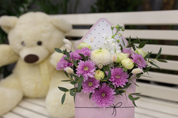 Composition of fresh flowers (chrysateme, rose, matiola. Colors light green, lilac) in a gift box in the form of an envelope