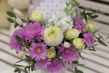 Composition of fresh flowers (chrysateme, rose, matiola. Colors light green, lilac) in a gift box in the form of an envelope