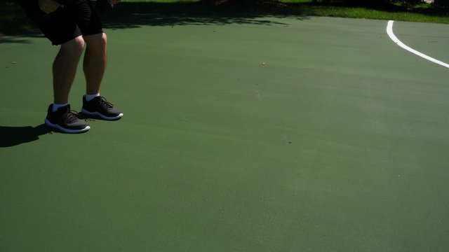 Man working out, doing triceps kickbacks, training, exercising outdoors in a park on a sunny summer day, 60fps.