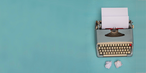 Vintage typewriter and crumpled papers with copy space banner