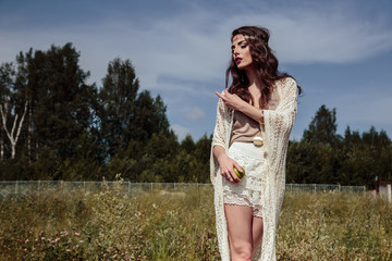Beautiful brunette young woman in a stylish summer knit clothes posing outdoor. Fashion beauty...