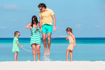 Happy family playing together on white beach