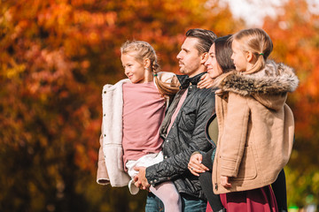 Portrait of happy family of four in autumn day