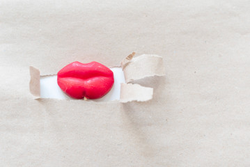 candy lips in a paper hole. creative minimalistic concept. pumped up lips.