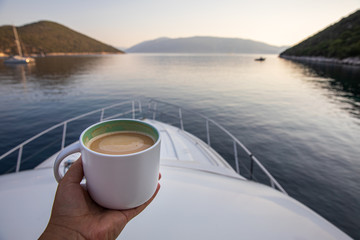 Early summer morning with cup of coffee cappuccino on a yacht in the Antisamos bay, Kefalonia...