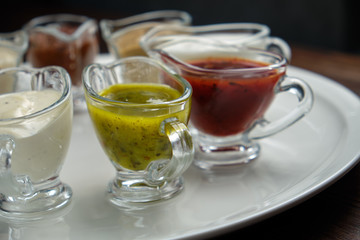 sauces in bowls on a dark wooden background. menu for catering