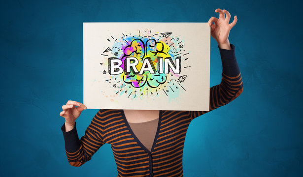 Young person holding white paper in front of her head with colorful brain concept