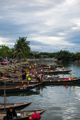 Fototapeta na wymiar Imagen Del Río con sus barcos en la ciudad de Hoi An, en Vietnam, durante el verano