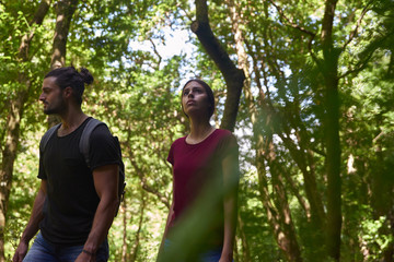 Obraz premium Couple strolling among the trees in the forest