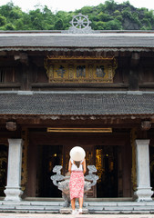 Imagen de una mujer joven de espaldas en un templo de Vietnam