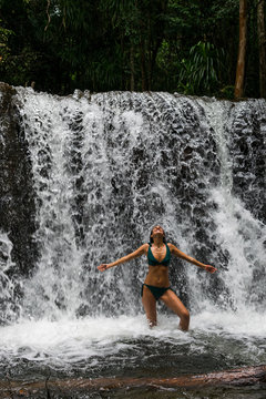 Imagen de una joven mujer en bikini en una cascada en una reserva natural de la isla de Phu Quoc en Vietnam durante el verano