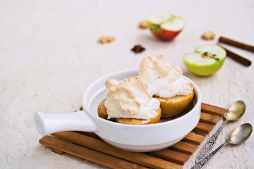 Autumn dessert, baked apples with meringue on a light concrete background. Thanksgiving Day. Harvest apples. Selective focus.