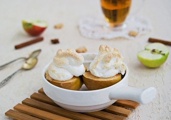 Autumn dessert, baked apples with meringue on a light concrete background. Thanksgiving Day. Harvest apples. Selective focus.