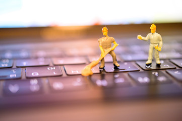 Miniature Worker model cleaning computer's dirty keyboard for hygenic, medical, clean purpose