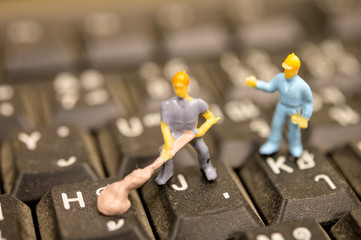 Miniature Worker model cleaning computer's dirty keyboard for hygenic, medical, clean purpose