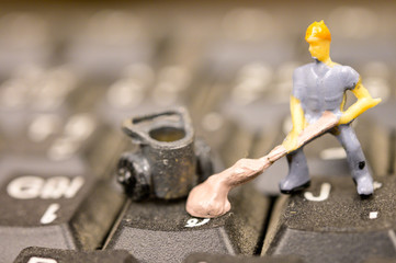 Miniature Worker model cleaning computer's dirty keyboard for hygenic, medical, clean purpose